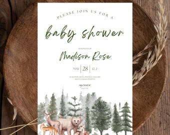 May include: A white baby shower invitation with green text that reads "Please join us for a baby shower in honor of Madison Rose May 28 12-2 registered at". The invitation features a watercolor illustration of a forest scene with a bear, deer, and fox.