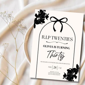 Könnte beinhalten: Eine cremefarbene Einladungskarte mit schwarzem Text und floralen Akzenten. Der Text lautet "R.I.P Twenties, Olivia is turning Thirty." Die Karte enthält das Datum 28. Mai und die Uhrzeit 7-12. Eine schwarze Schleife und ein Blumendesign befinden sich oben.