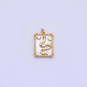 Peut inclure: Pendentif doré avec un cadre rectangulaire, représentant un serpent avec des accents noirs. Le pendentif comprend une étoile et un croissant de lune. Le fond a un effet nacré. Le pendentif est conçu pour les bijoux.