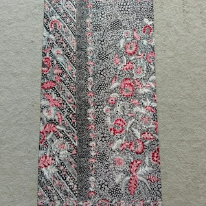 Könnte beinhalten: Ein schwarzer und weißer Stoff mit einem roten Blumenmuster. Der Stoff hat ein sich wiederholendes Muster aus Blumen und Blättern.