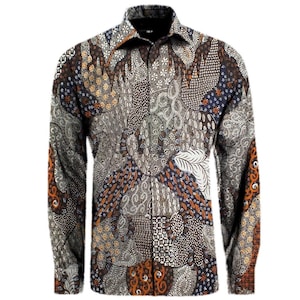 Könnte beinhalten: Ein langärmeliges Hemd mit detailliertem Batikmuster. Das Hemd weist eine Mischung aus braunen, blauen, orangefarbenen und weißen Designs auf. Kragen und Manschetten sind sichtbar und zeigen die komplizierte Textilkunst.