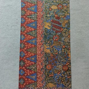 May include: A red, blue, and gold patterned fabric with a floral design. The fabric has a geometric pattern on the left side and a floral pattern on the right side.