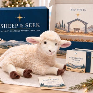 May include: A plush cream-colored lamb toy sits in front of a blue box labeled Sheep & Seek A Christ-Centered Advent Tradition. Beside the lamb is a set of numbered cards, including one titled God's Promise to Abram, and a Parent Guide card.