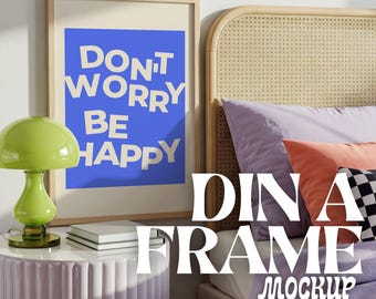May include: A framed poster with a blue background and white text that reads "Don't Worry Be Happy" hanging on a wall above a bed with a light purple headboard and bedding. The bed has a pink nightstand with a green lamp and two books on top.