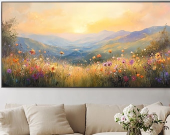 Puede incluir: Una gran pintura de paisaje rectangular representa un prado vibrante lleno de coloridas flores silvestres bajo una cálida puesta de sol dorada. Se ven montañas a lo lejos y la obra está enmarcada en negro.