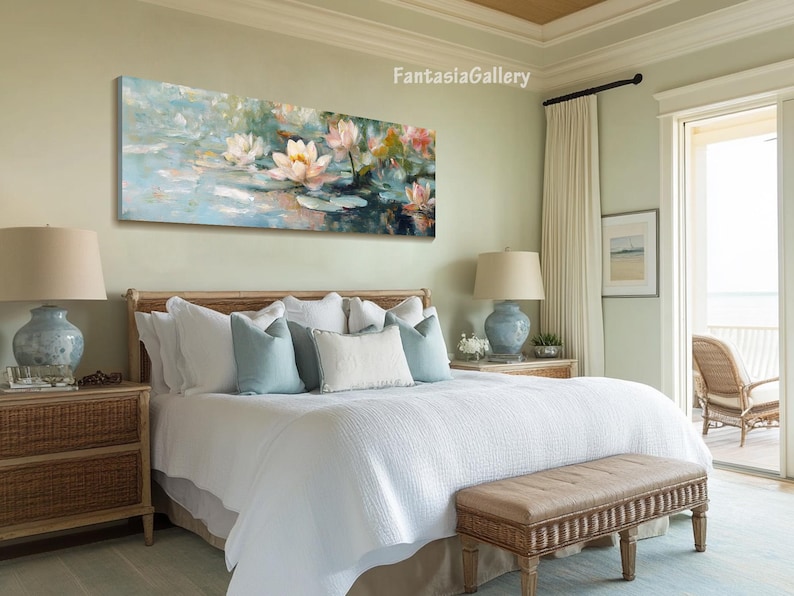 May include: A white bed with a white duvet cover and a brown wicker headboard. The bed has a white bedspread and a brown wicker bench at the foot of the bed. There is a painting of pink water lilies on the wall above the bed.