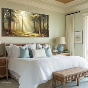 May include: A white bed with a light blue and white patterned comforter and pillows. The bed is in a bedroom with a large window and a painting of a forest scene above the headboard.