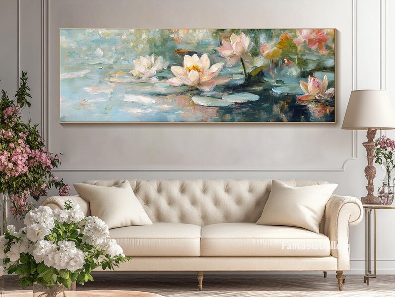 May include: A painting of white water lilies with pink accents on a blue and green background. The painting is framed and hanging on a wall above a white couch.