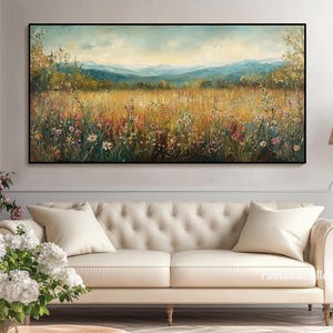 May include: A painting of a field of wildflowers in a meadow with a mountain range in the background. The sky is blue and there are clouds in the sky. The painting is framed in a black frame.
