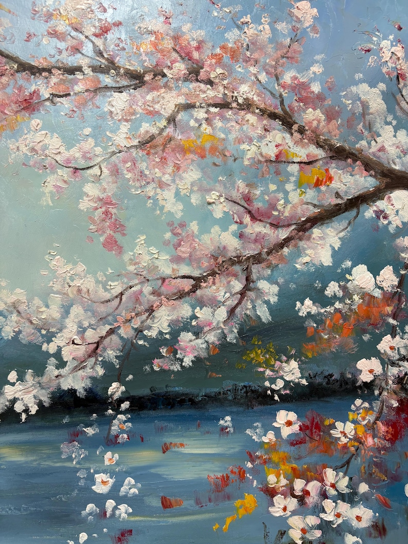 May include: A painting of a cherry blossom tree with pink and white flowers, hanging over a blue body of water. The water is painted with a textured brushstroke and reflects the light of the sky.