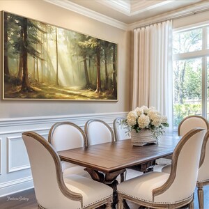 May include: A dining room with a large framed painting of a forest scene above a wooden table with six white upholstered chairs. The table is set with a vase of white flowers.