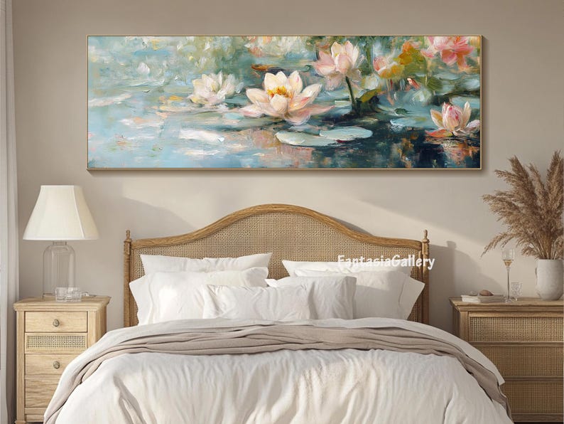 May include: A painting of white water lilies with pink accents on a blue and green background. The painting is framed and hanging above a white bed with a wooden headboard.