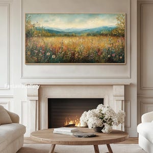 May include: A painting of a field of wildflowers with a mountain range in the background. The painting is in a gold frame and is hanging on a wall above a fireplace.