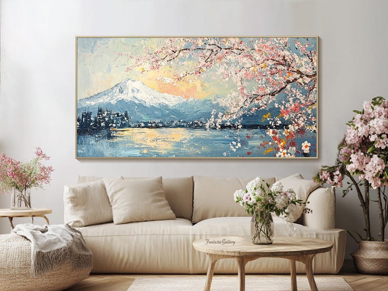May include: A painting of a mountain range with a lake in the foreground. The mountain range is covered in snow and the lake is reflecting the sky. There are pink cherry blossoms in the foreground.