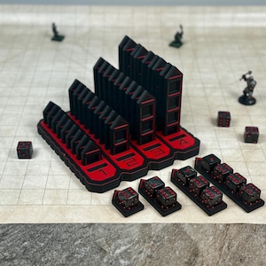 May include: Black and red dice tower with four numbered slots. The tower is made of 3D printed plastic and has a red trim. There are several black dice on the table in front of the tower.