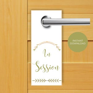 May include: White door hanger with green foliage and gold lettering that reads "In Session".