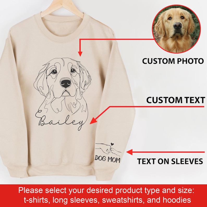 May include: Beige sweatshirt with a line drawing of a golden retriever dog and the name "Bailey" printed below. The text "DOG MOM" is printed on the sleeve. The sweatshirt can be customized with a photo and text.