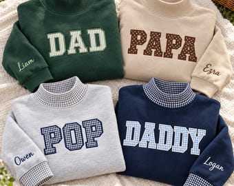 May include: Four mock neck sweatshirts in dark green, beige, light gray, and navy blue. The sweatshirts feature embroidered block lettering reading DAD, PAPA, POP, and DADDY with patterned fabric fills. Each sleeve is embroidered with a name.