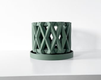 May include: A sage green cylindrical plant pot featuring a repeating geometric diamond lattice pattern throughout its exterior walls. The pot sits securely on a matching circular base tray, creating a cohesive unit with a matte finish.