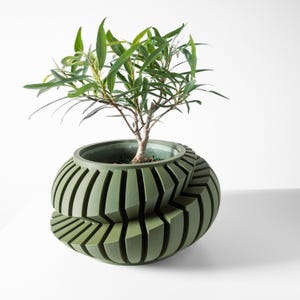 May include: A green, geometric planter with a plant growing out of it. The planter is made of a textured material and has a unique, modern design.