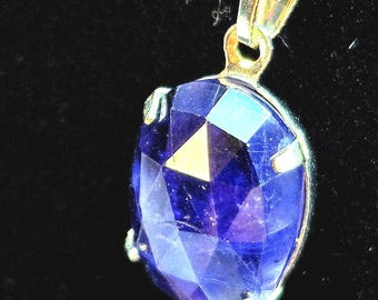 Ciondolo in iolite blu: ovale sfaccettato con effetto cangiante e castone placcato argento.