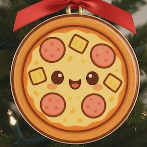 Może przedstawiać: Okrągła ozdoba choinkowa w kształcie pizzy z uśmiechniętą twarzą, pepperoni i serem. Ozdoba zawieszona jest na czerwonej wstążce i kokardzie, na choince.