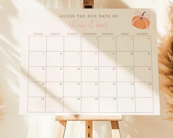 May include: A white calendar on an easel with the text "GUESS THE DUE DATE OF Baby Roberts." A pumpkin illustration with a pink bow is in the upper right corner. The calendar grid is divided into squares for each day of the month.