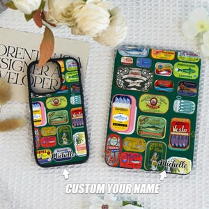 May include: A phone case and tablet case with a green background and a pattern of vintage sardine can labels in various colors. The phone case and tablet case have the name "Michelle" on them.
