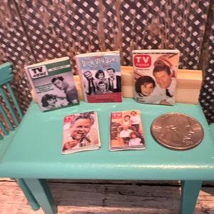 Puede incluir: Cinco revistas en miniatura de TV Guide vintage sobre una mesa turquesa con una moneda de veinticinco centavos sobre la mesa. Las revistas presentan a Dick Van Dyke, TV Guide y TV News.