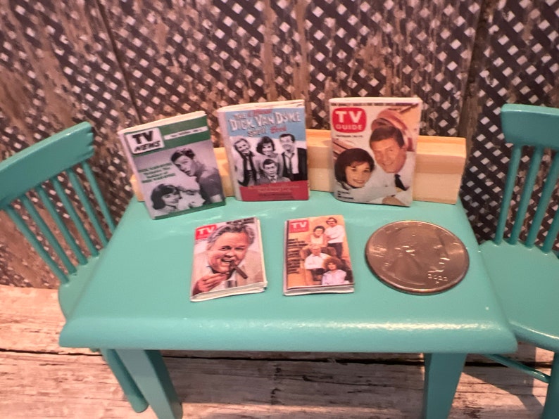 Puede incluir: Cinco revistas en miniatura de TV Guide vintage sobre una mesa turquesa con una moneda de veinticinco centavos sobre la mesa. Las revistas presentan a Dick Van Dyke, TV Guide y TV News.