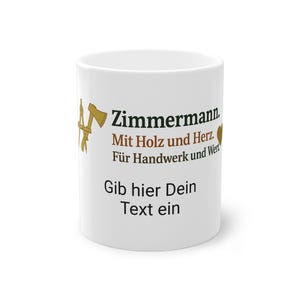 以下が含まれることがあります： 「Zimmermann」というドイツ語のテキストと、黒と茶色のその他のテキストが書かれた白いセラミックマグ。マグには大工道具のグラフィックが描かれています。下のテキストは「Gib hier Dein Text ein」と書かれています。