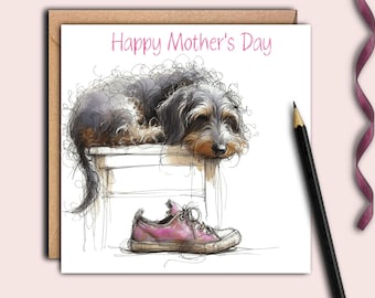 May include: A greeting card with a hand-drawn illustration of a dog sleeping on a stool with a pink shoe next to it. The card says "Happy Mother's Day" in pink lettering.