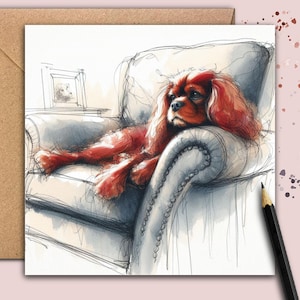 Op de afbeelding: Waterverfillustratie van een Cavalier King Charles Spaniel die rust op een gecapitonneerde fauteuil. De hond heeft rood haar. Een potlood en een blanco kaart staan in de afbeelding.
