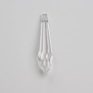 May include: A clear crystal teardrop pendant with a faceted design.