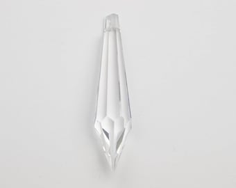 May include: A clear crystal teardrop pendant with a pointed tip. The pendant is faceted and has a smooth, polished finish.