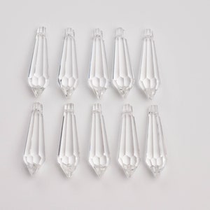 May include: Ten clear crystal teardrop-shaped pendants with a faceted design.