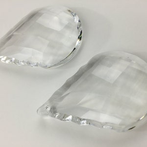 May include: Two clear glass teardrop-shaped crystal prisms with faceted edges.