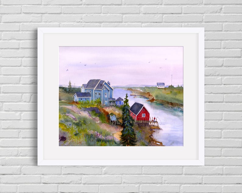 May include: Watercolor painting of a coastal scene with a red building and a blue building. The painting is framed in a white border and depicts a river, buildings, and a cloudy sky. The artwork is displayed on a white brick wall.