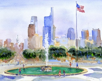 Op de afbeelding: Een aquarel schilderij van een fontein voor een skyline van een stad. De fontein is op de voorgrond en is omgeven door groene bomen. De skyline van de stad is op de achtergrond en omvat hoge gebouwen, waaronder een wolkenkrabber met een Amerikaanse vlag die aan de top wappert.