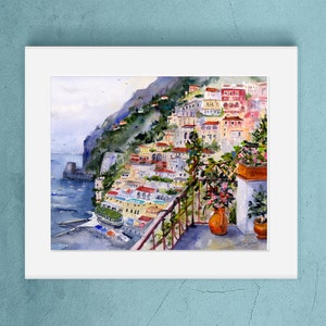 May include: Watercolor painting of a colorful Italian village on a cliffside overlooking the sea. The painting features a balcony with a potted plant and a view of the ocean.