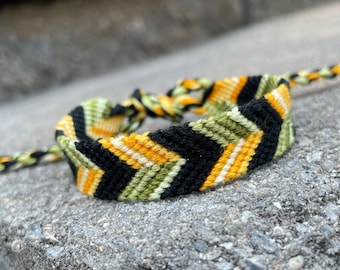 Friendship bracelet in chevron (arrowhead) pattern - black, yellow, & green - handmade macrame jewelry