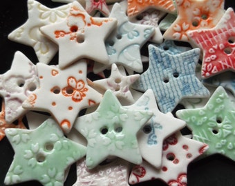May include: A collection of ceramic star-shaped buttons with various patterns and colors, including blue, green, red, and white.