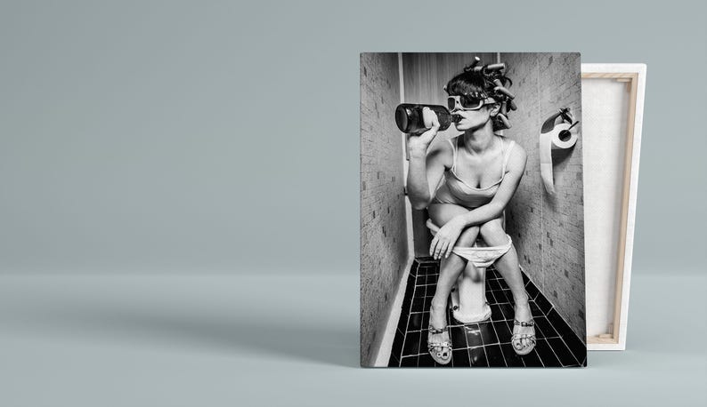Puede incluir: Foto en blanco y negro de una mujer sentada en un inodoro en un ba&ntilde;o, bebiendo de una botella. Lleva gafas de sol y un vestido. El inodoro es blanco y las paredes del ba&ntilde;o est&aacute;n enlosadas.
