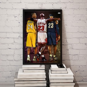 May include: A framed illustration of three basketball players, Michael Jordan, Kobe Bryant, and LeBron James, standing together in their iconic jerseys. Jordan is wearing a red and black Chicago Bulls jersey with the number 23, Bryant is wearing a yellow and purple Los Angeles Lakers jersey with the number 24, and James is wearing a blue and gold Cleveland Cavaliers jersey with the number 23.