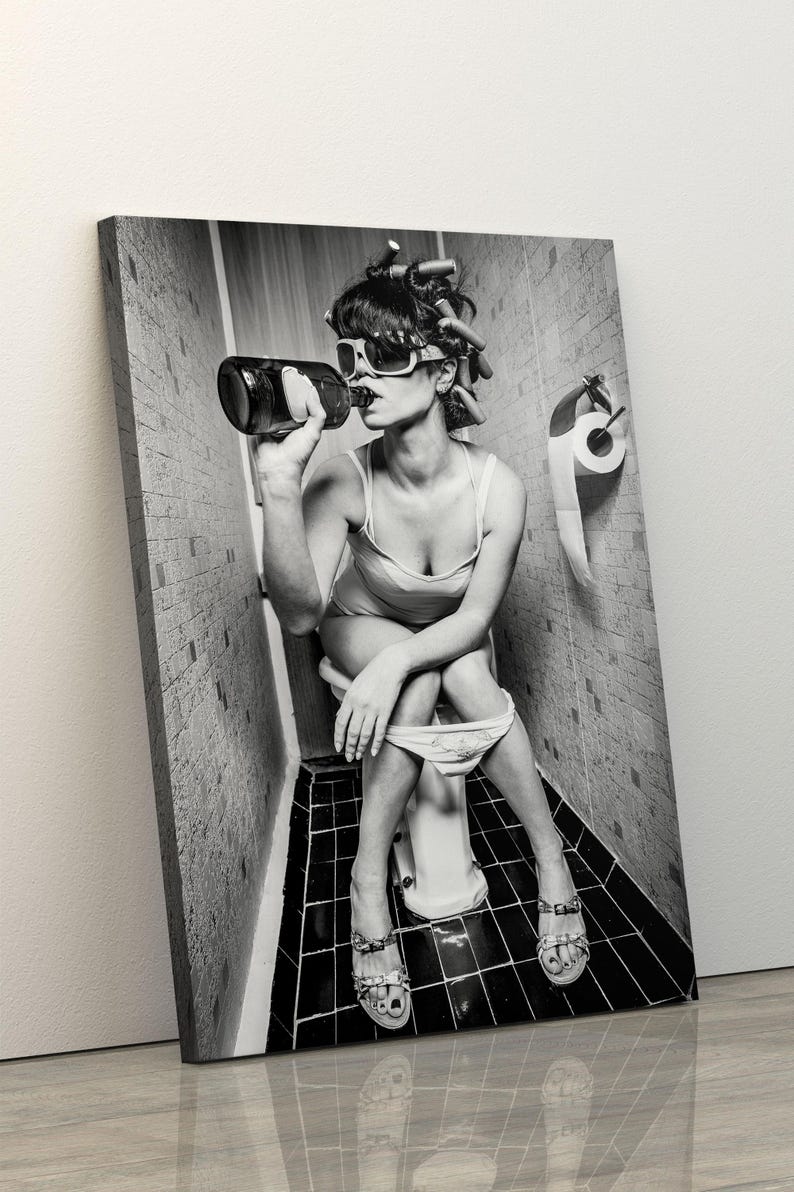 Puede incluir: Una foto en blanco y negro de una persona sentada en un inodoro en un ba&ntilde;o. La persona lleva gafas de sol y tiene el pelo en rulos. Est&aacute; sosteniendo una botella y bebiendo de ella.