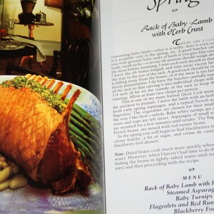 May include: A close-up of a roasted rack of baby lamb with a herb crust, served with steamed asparagus, baby turnips, flageolet beans, and red runner beans. The dish is presented on a white and blue patterned plate. The text "Rack of Baby Lamb with Herb Crust" is visible in the bottom right corner of the image.