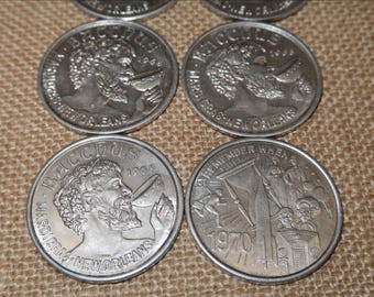 Könnte beinhalten: Eine Sammlung silberfarbener Bacchus Mardi Gras-Münzen. Die Münzen zeigen das Profil eines Mannes mit Bart und die Worte "Bacchus", "Mardi Gras" und "New Orleans". Eine Münze ist von 1970 und trägt die Aufschrift "Remember When".