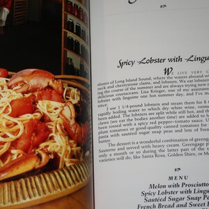 May include: A close-up of a plate of linguine pasta with lobster, tomatoes, and a red sauce. The text "Spicy Lobster with Linguine" is visible in the background.
