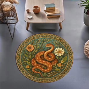Pode incluir: Tapete redondo com uma ilustração detalhada de uma cobra enrolada entre flores e folhagens. O tapete tem um fundo verde-azulado com uma borda e detalhes dourados. A cobra é marrom com um design padronizado, e as flores são amarelas e brancas.