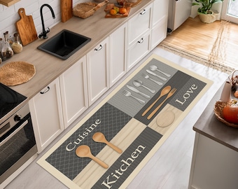 May include: A rectangular kitchen floor mat with a cream border and a patchwork design. The mat features gray and beige squares with utensil and text graphics. The words "Cuisine", "Kitchen", and "Love" are printed on the mat.